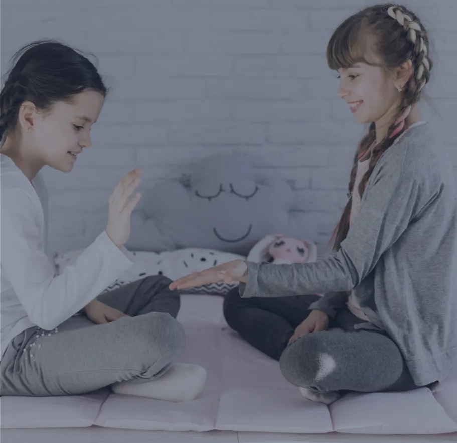 Dos niñas jugando sentadas en el piso, imagen de crianza e infancia