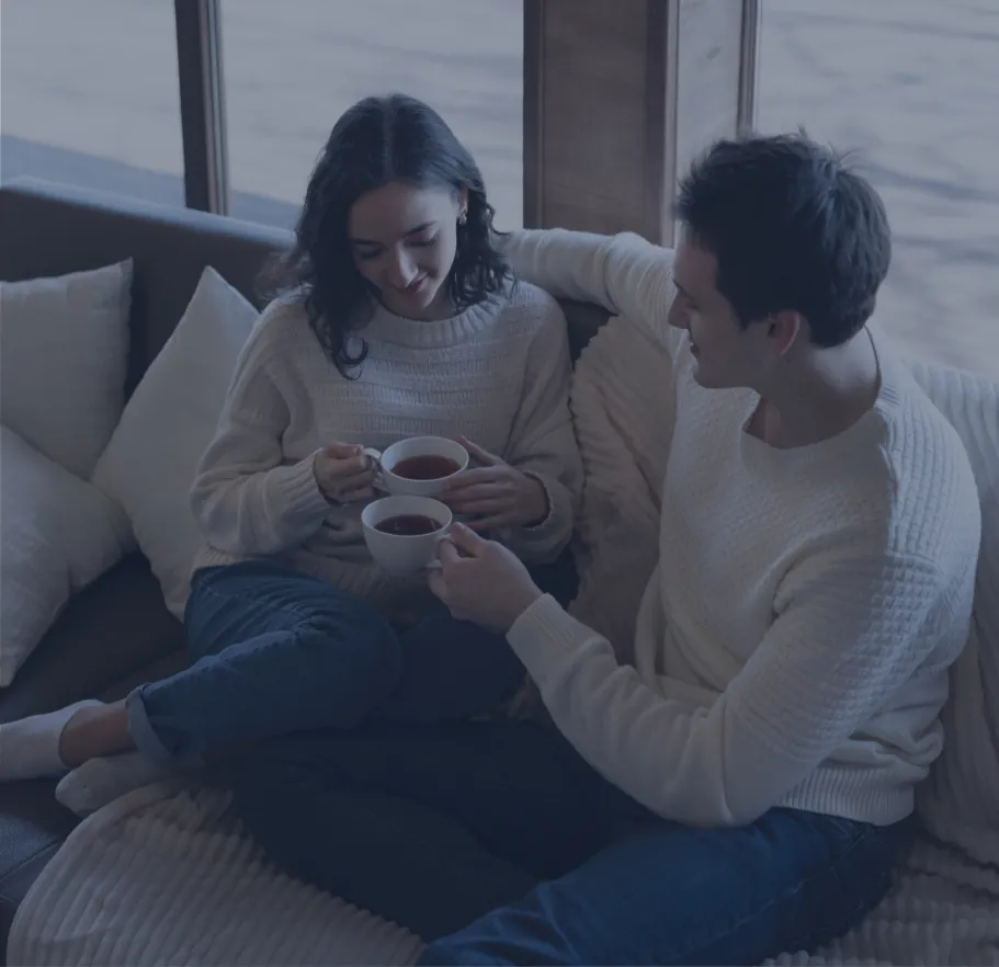 Pareja compartiendo una taza de té en el sofá, psicoterapia de pareja