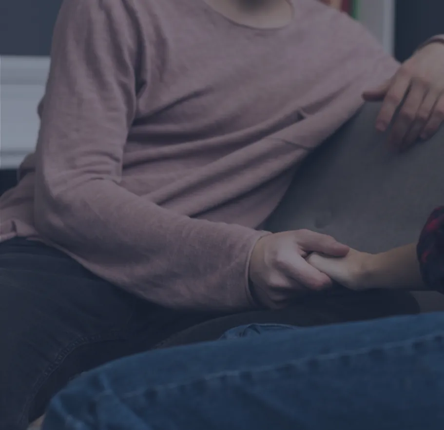 Persona sentada con las manos entrelazadas durante una sesión de psicoterapia individual